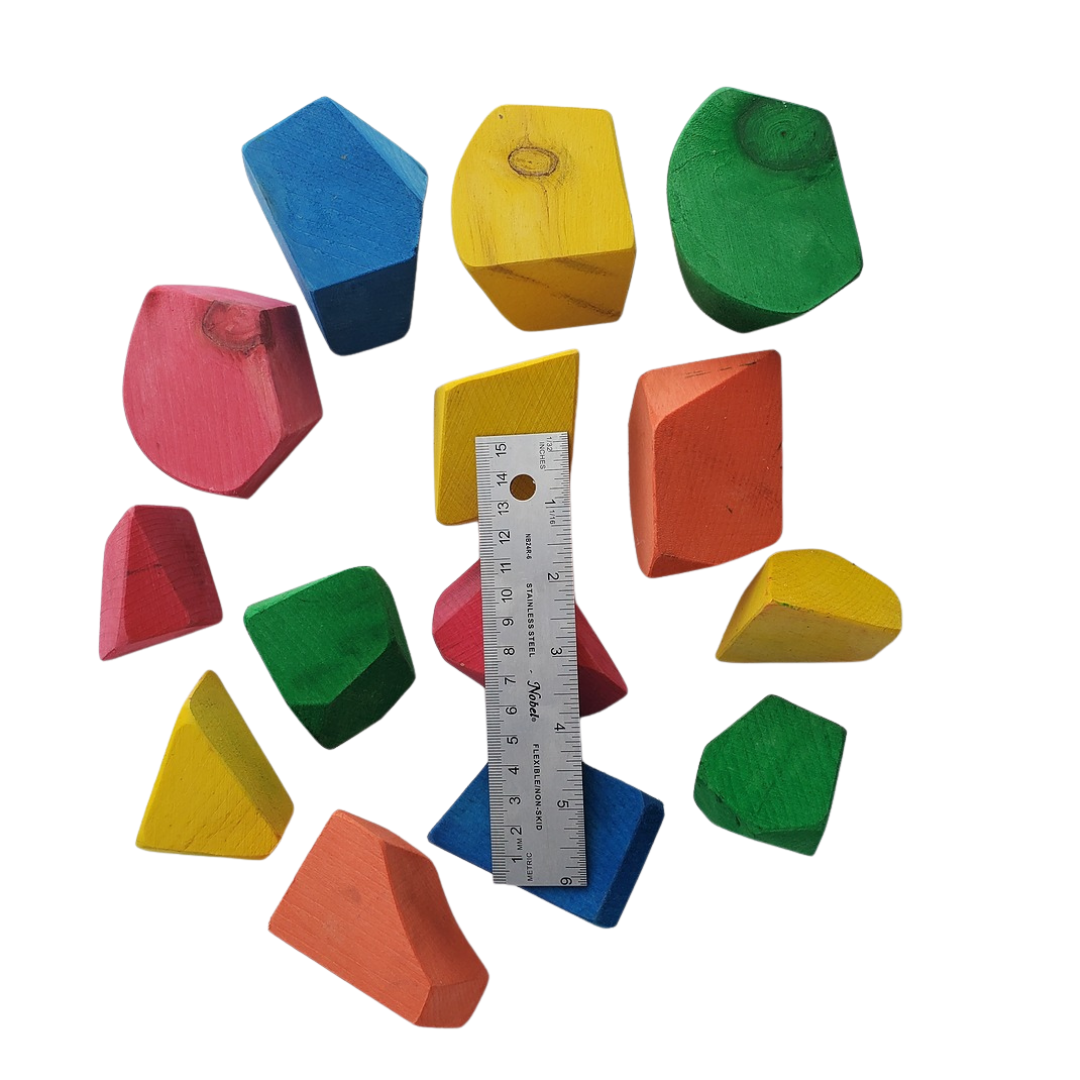 Colorful geometric wooden blocks with a ruler for scale on a white background