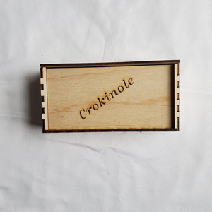 Wooden box with 'Crokinole' engraving on a white background