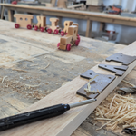 Wooden toy train on a workbench with tools and wood shavings 7