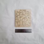 Cat-themed wooden puzzle on a white surface with a ruler for scale. 7