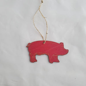 Red pig-shaped ornament hanging on a white background