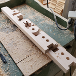 Wooden letters 'L', 'E', and 'O' on a workbench with sawdust 5